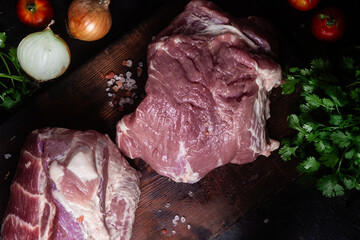 Raw pork neck on a wooden board on the table