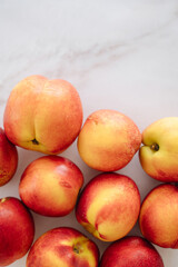 Fresh, ripe nectarines artfully arranged on a clean white table