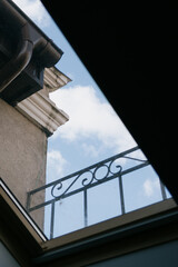 Skylight with sky view and balcony. The window offers a view of the overcast sky with a few clouds. historical architecture, with a window to the sky.