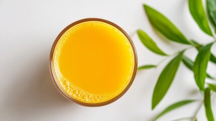 Overhead view of a glass of orange juice set against a white surface