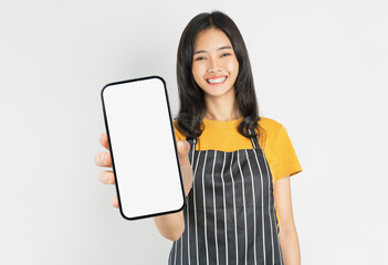 Happy Asian woman owner in black apron standing with holding smartphone on white background.