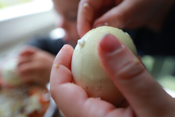 two child's hands cutting vegetables for salad close up