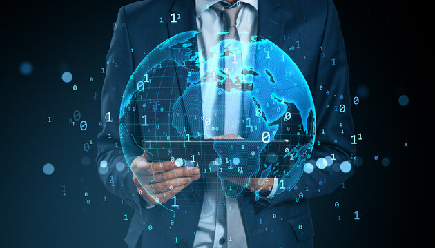 Businessman using tablet with holographic digital world map and binary code representing global data network and futuristic communication concept.