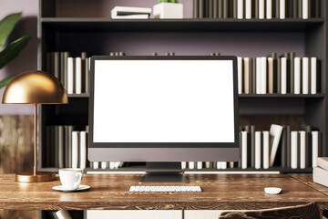 Modern desktop computer with blank screen on wooden desk in cozy home office with lamp,...