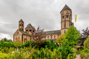 The historic Benedictine abbey church of Maria Laach, Germany, rising above a lush garden in front...