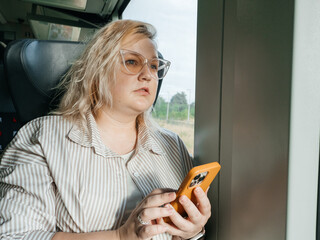 Plus Size Woman Traveling by Train and Using Smartphone