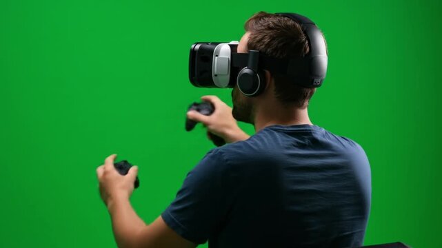 A man wearing a vr headset and holding controllers in front of a green screen for virtual reality gaming