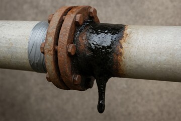 Diesel Rig Spill concept. Rusty pipe with leaking fluid and corrosion visible on fittings.