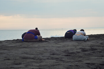 Maintaining their pose in quiet concentration, the girls continue holding their full forward...