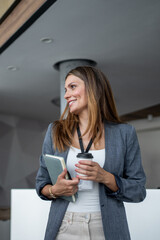 Businesswoman holding notebook and coffee, networking at conference
