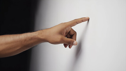 Finger Pointing Toward Wall with Dramatic Shadow