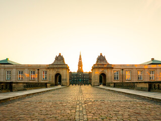Christiansborg Palace in Copenhagen, Denmark, bathed in the warm glow of sunrise, stands as a...