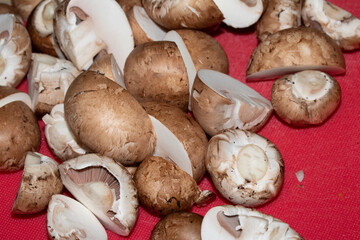 CLose up of chopped sliced mushrooms on red choopping board
