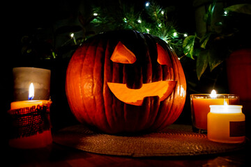 Halloween pumpkin with carved face growing in the dark, candles ans autumn decorations, perfect for...