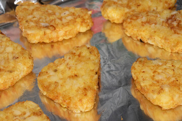 Close up of hash browns just out of the oven on tin foil