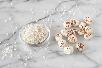 Close-up of a puffed lotus seed, makhana, and powder, an exotic plant ingredient