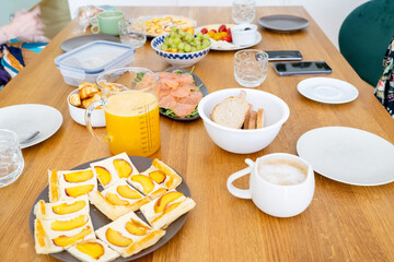 close-up captures a diverse brunch spread on a wooden table, highlighting beautifully arranged...