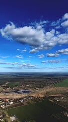  Aerial view of a rural village and farmlands under a dramatic blue sky, Serbia