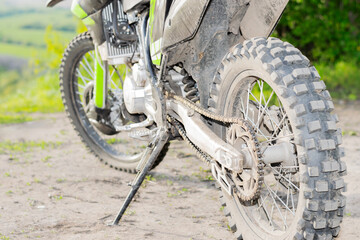 parked cross enduro motorcycle. rear wheel close-up