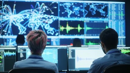 Analysts monitor global data from a command center with large screens displaying world maps and charts - Powered by Adobe