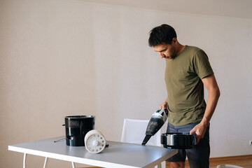 Remote wide view of housekeeper cleaning table with air humidifier using vacuum cleaner,...