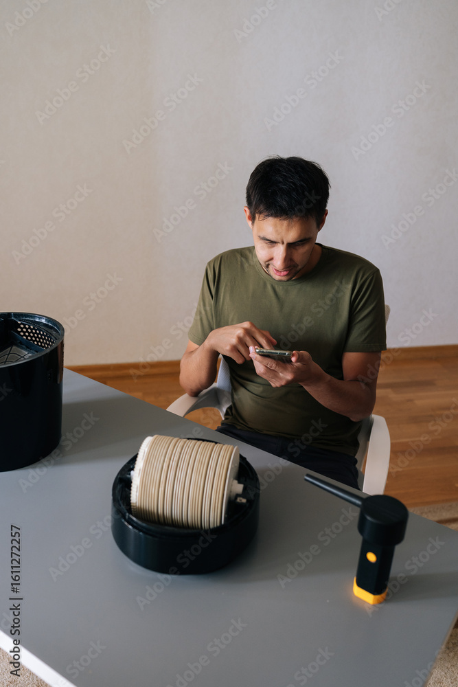 Poster vertical portrait of puzzled man cleaning air humidifier filter, referencing smartphone tutorial, sh