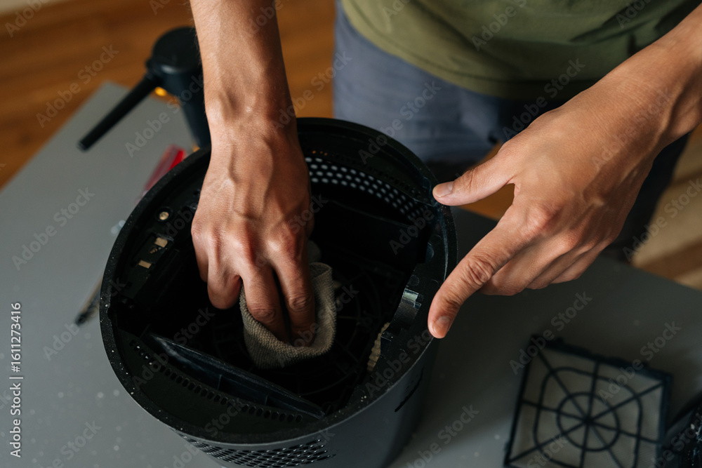 Aufkleber close-up top view of unrecognizable man disassembling and cleaning air humidifier filter standing by