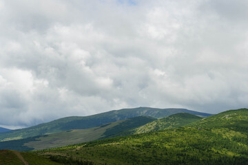 Obraz premium clouds over the mountains hills on layers landscape in summer 