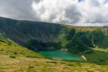 view from top of glacier cold lake in the mountains with green smarald waters and forest 
