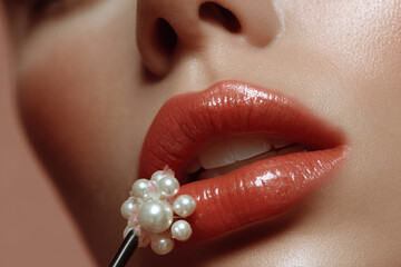Close-up of glossy lips with a pearl-adorned applicator, creating an elegant and luxurious beauty concept. A focus on radiant glamour.