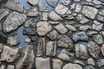 old cobblestone path with irregularly shaped stones and natural wear