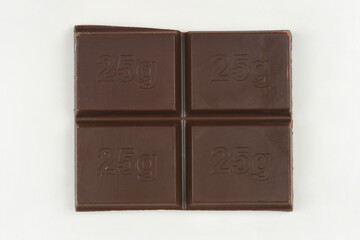 This close-up image shows dark chocolate divided into four squares, each embossed with 