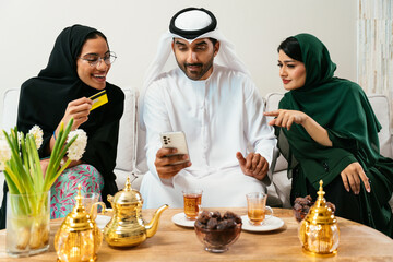 Emirati friends shopping online together at home