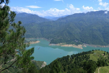 Obraz premium Tehri Lake, nestled in the Garhwal Himalayas of Uttarakhand, is a stunning man-made reservoir created by the Tehri Dam. Surrounded by lush green hills and snow-capped peaks.