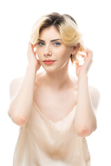 Fototapeta premium A young blonde girl with clear skin in a satin top. Beauty portrait of a woman on a white background in the studio.