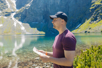 Beautiful panoramic view of a clear alpine lake surrounded by green forest and rugged mountain...