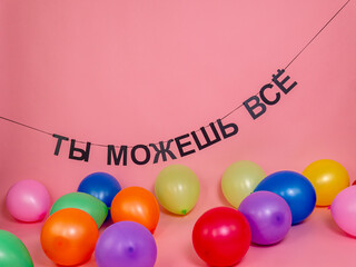 The inscription "You can do everything" congratulations and colorful balloons on a pink background, holiday card