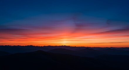 Obraz premium Vibrant Sunset over Misty Mountain Range