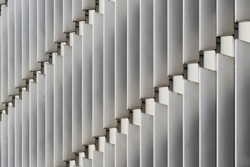 Abstract office facade with rhythmic vertical metal fins in staggered alignment