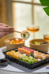 A vibrant assortment of fresh sushi, including nigiri, rolls, and sashimi, beautifully arranged on a dark slate. The vibrant colors and textures highlight the variety and freshness of the seafood.