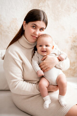 a mother with a baby, a mom holding her son's little child in her arms, hugging and kissing him, maternal love and care, mother and child