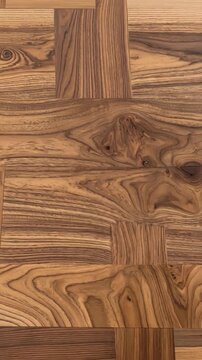 Intricate parquet pattern of interlaced wood strips featuring a warm, natural brown hue and visible wood grain texture detail.