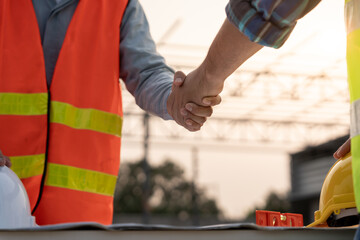 Fototapeta premium Construction team hands shaking greeting start up plan new project contract in office center at construction site, industry ,architecture, partner, teamwork, agreement, property, contacts.