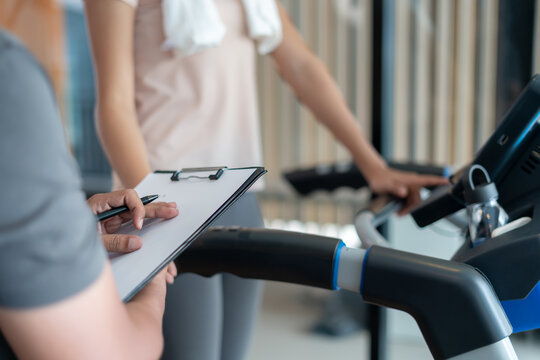 woman is running on Treadmills, trainer record and advice for exercisers and are checking how to exercise properly. correct exercise. diet, body shape, healthy, strong, care, gym, fitness, vacation