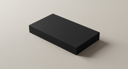 A stack of black rectangular cards resting on a neutral-toned surface.