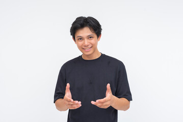 A welcoming young Asian man with open hands extended forward, inviting connection. Isolated on a...