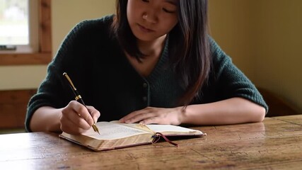 Woman writes in book with pen