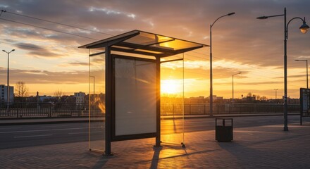 A bus shelter stands illuminated by the warm glow of a sunset.