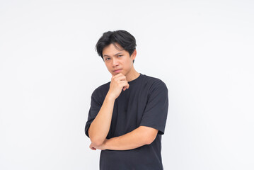 A skeptical young Asian man staring intently with one eyebrow lifted and hand on chin. Isolated on...