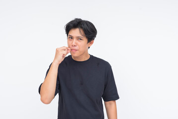 A disciplined young Asian man zipping his lips with a finger, signaling he’ll stay silent....